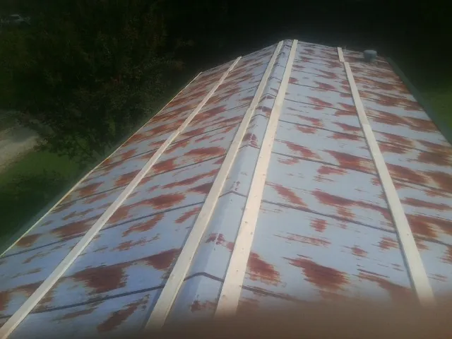 Rusted metal roof panels with new wood purlins before replacement — Storm Damage Roof Repair in Bridgehampton by Roofing Brothers